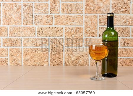 Wine bottle and glass on brick wall background