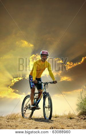 young man riding moutain bike mtb on land dune against dusky sky in evening background  use for spor