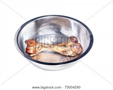 Dog's beef bone for chewing in metal bowl shot on white