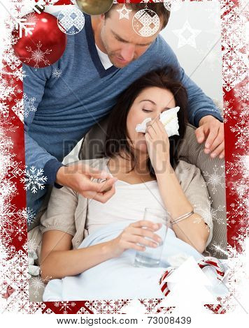 Handsome man taking care of his sick girlfriend against christmas themed frame