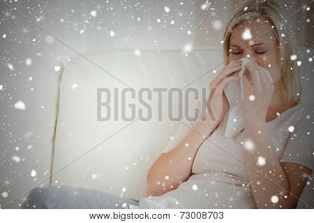 Composite image of woman blowing her nose against snow falling