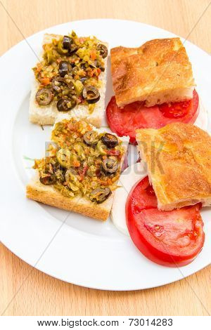 Preparing Vegetarian Sandwiches With Pickle Muffaletta, Tomatoes And Mozzarella Cheese.