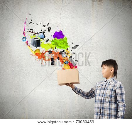 Young boy splashing colorful paint from carton box