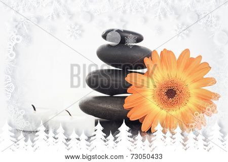 Fir tree forest and snowflakes against unlighted candles pebble stack an orange gerbera
