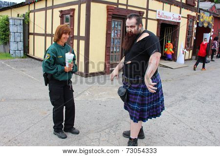 MUSKOGEE, OK - Sept. 13: A weird zombie in Scottish kilt terrorizing visitors at the village before the Castle Zombie Run at the Castle of Muskogee in Muskogee, OK on September 13, 2014. 