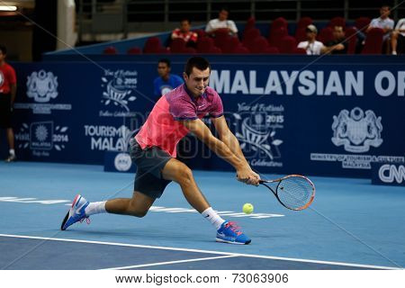 SEPTEMBER 23, 2014 - KUALA LUMPUR, MALAYSIA: Bernard Tomic of Australia makes a backhand return in his first round match at the Malaysian Open Tennis 2014 event. This is an ATP sanctioned tournament.