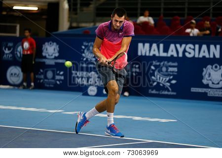 SEPTEMBER 23, 2014 - KUALA LUMPUR, MALAYSIA: Bernard Tomic of Australia makes a backhand return in his first round match at the Malaysian Open Tennis 2014 event. This is an ATP sanctioned tournament.
