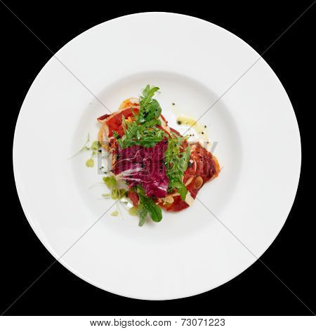 Fish and potatoes fried with romesco sauce isolated on black