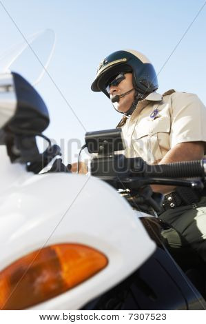 Poliziotto seduto sulla moto basso angolo di visualizzazione (basso angolo di visualizzazione)