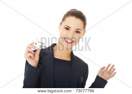 Young businesswoman with plane toy in hand