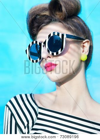 Face close up of beautiful young woman wearing stripy sunglasses