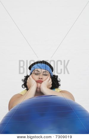 Mujer con sobrepeso sin inspiración descansando en el retrato de la bola del ejercicio