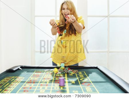 Joven celebrando con fichas en la mesa de ruleta