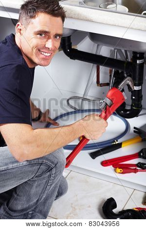 Plumber man with tools in the kitchen. Plumbing and renovation.