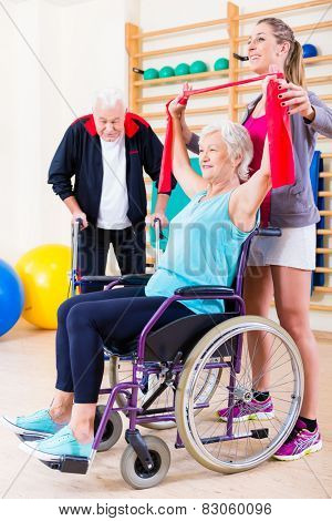 Seniors in physical rehabilitation therapy with trainer