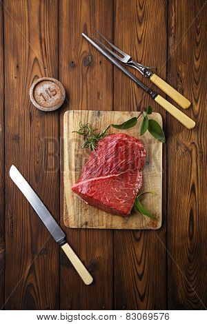 raw beef meat fillet  on wooden  table with meat fork and 1lb iron weight