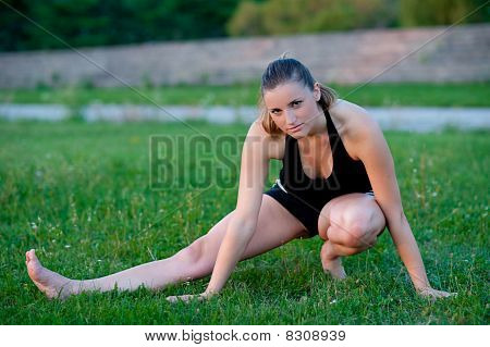 Cute adolescente s'étend ses jambes sur une grasss vert