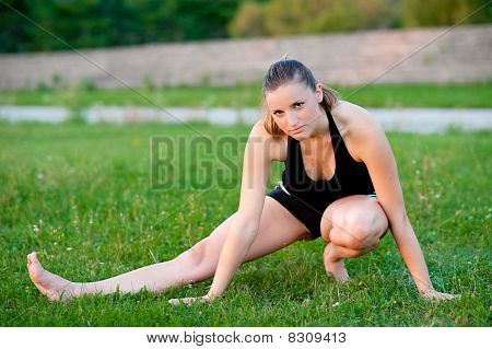 Cute adolescente s'étend ses jambes sur une grasss vert