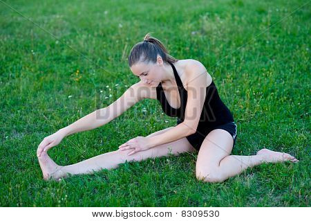 Cute adolescente s'étend ses jambes sur une grasss vert