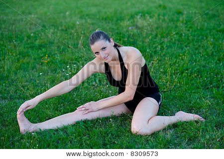Cute adolescente s'étend ses jambes sur une grasss vert