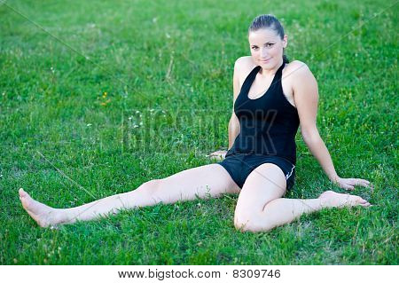 Cute adolescente s'étend ses jambes sur une grasss vert