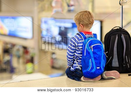 little boy with backpack waiting in the aiport
