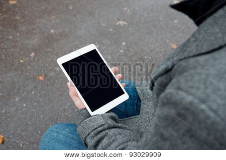 Digital tablet with isolated screen in male hands.