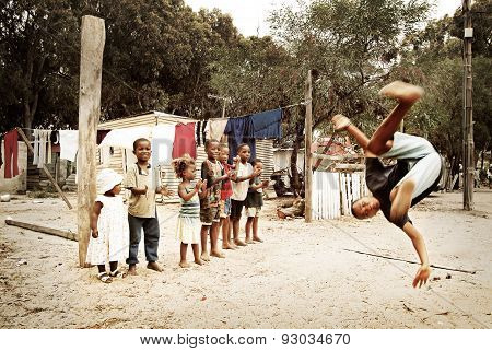 Boy jumping, making a salto in township, South Africa.