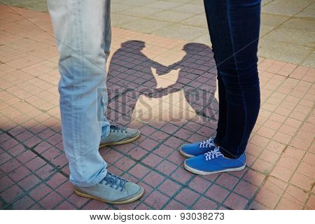 Young couple in jeans and sports shoes standing on trottoire