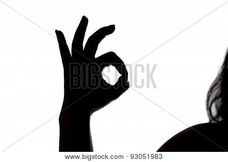 Silhouette of woman showing okey