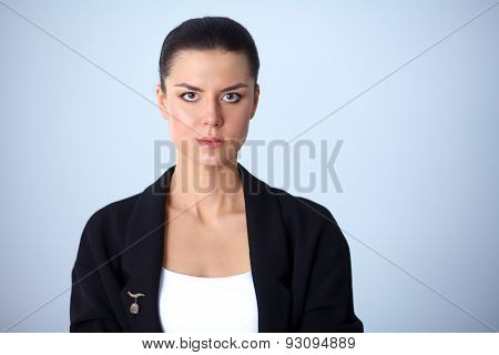 A young woman standing, isolated on graybackground