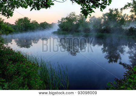 Nice foggy landscape with river at early morning tme