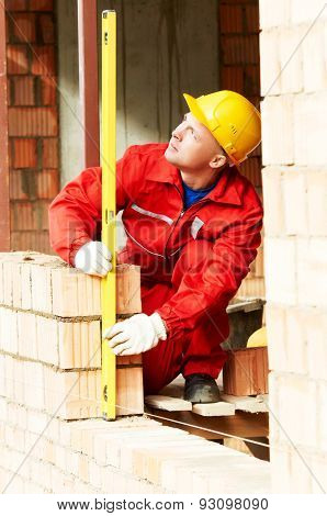 construction mason worker bricklayer making a brickwork with trowel and cement mortar