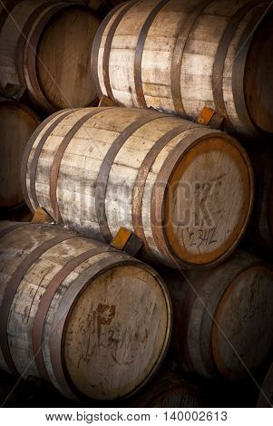 Wine barrels stacked in the old cellar of the winery.