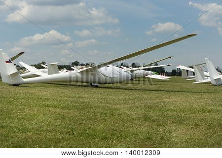gliders at green airfield with blue sky in sunny day