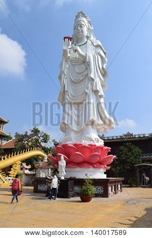 Binh Duong Vietnam June 16 2016: people praying at the big statue of Bodhisattva at Buddhist Chau Thoi temple