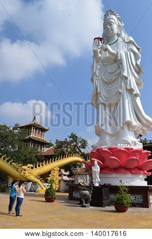 Binh Duong Vietnam June 16 2016: people praying at the big statue of Bodhisattva at Buddhist Chau Thoi temple