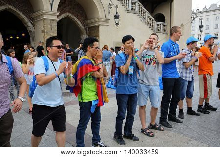 CRACOW POLAND - JULY 24 2016: Pilgrims of World Youth Day sing and dance on the Main Square in Cracow. Poland