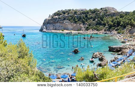 Rhodes, Greece- June 21 2016. Tourists enjoying the sea during a warm summer day in the popular Antony Quinn bay or Rhodes island. Named after the famous actor who bought the land during the filming of The Guns of Navarone in Rhodes. However, it was later