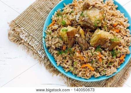 Traditional Uzbek pilaf of devzira rice and lamb blank space for text on blue background