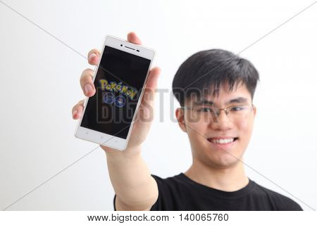 Kuala Lumpur,Malaysia 23th July 2016,teenager holding a smartphone with pokemon go logo on the screen