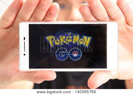 Kuala Lumpur,Malaysia 23th July 2016,teenager holding a smartphone with pokemon go logo on the screen