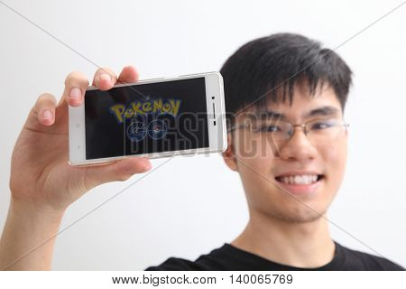 Kuala Lumpur,Malaysia 23th July 2016,teenager holding a smartphone with pokemon go logo on the screen