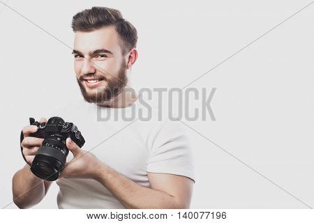young bearded photographer taking pictures with digital camera.