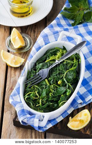 Boiled wild herbs Vlito with lemon juice and olive oil. The traditional Greek snack. Selective focus.