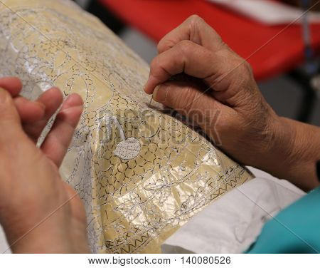 Hands Of The Elderly While Embroidering A Lace