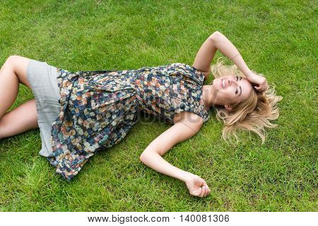 Young Woman Relaxing On A Beautiful Green Meadow.