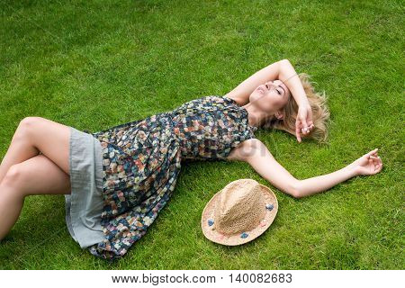 Young Woman Relaxing On A Beautiful Green Meadow.