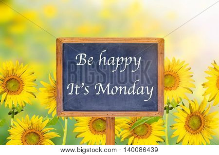 Be happy it's monday on signpost in beautiful sunflower background