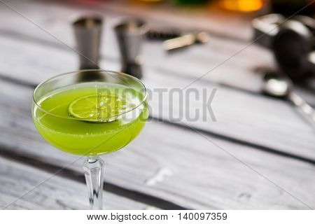 Green drink in glass. Slice of lime in beverage. Alcoholic cocktail with rum. Proven recipe of kiwi daiquiri.